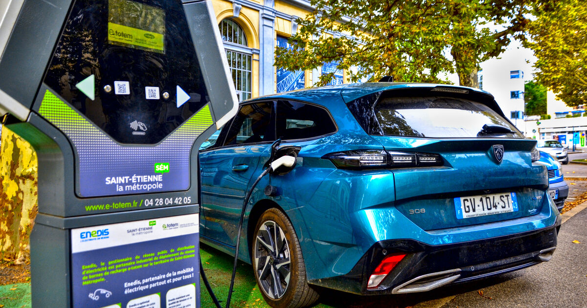 Saint-Etienne, France - September 1st 2024 : Blue Peugeot 308 III (since 2021) in charge in the street on a public recharging terminal. It's the hybrid version of this car.