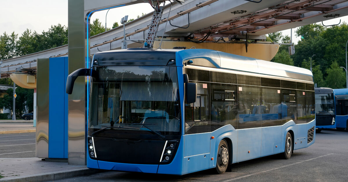 An electric bus at a charging station has its pantograph connected to a high-voltage connector at the final stop of the route